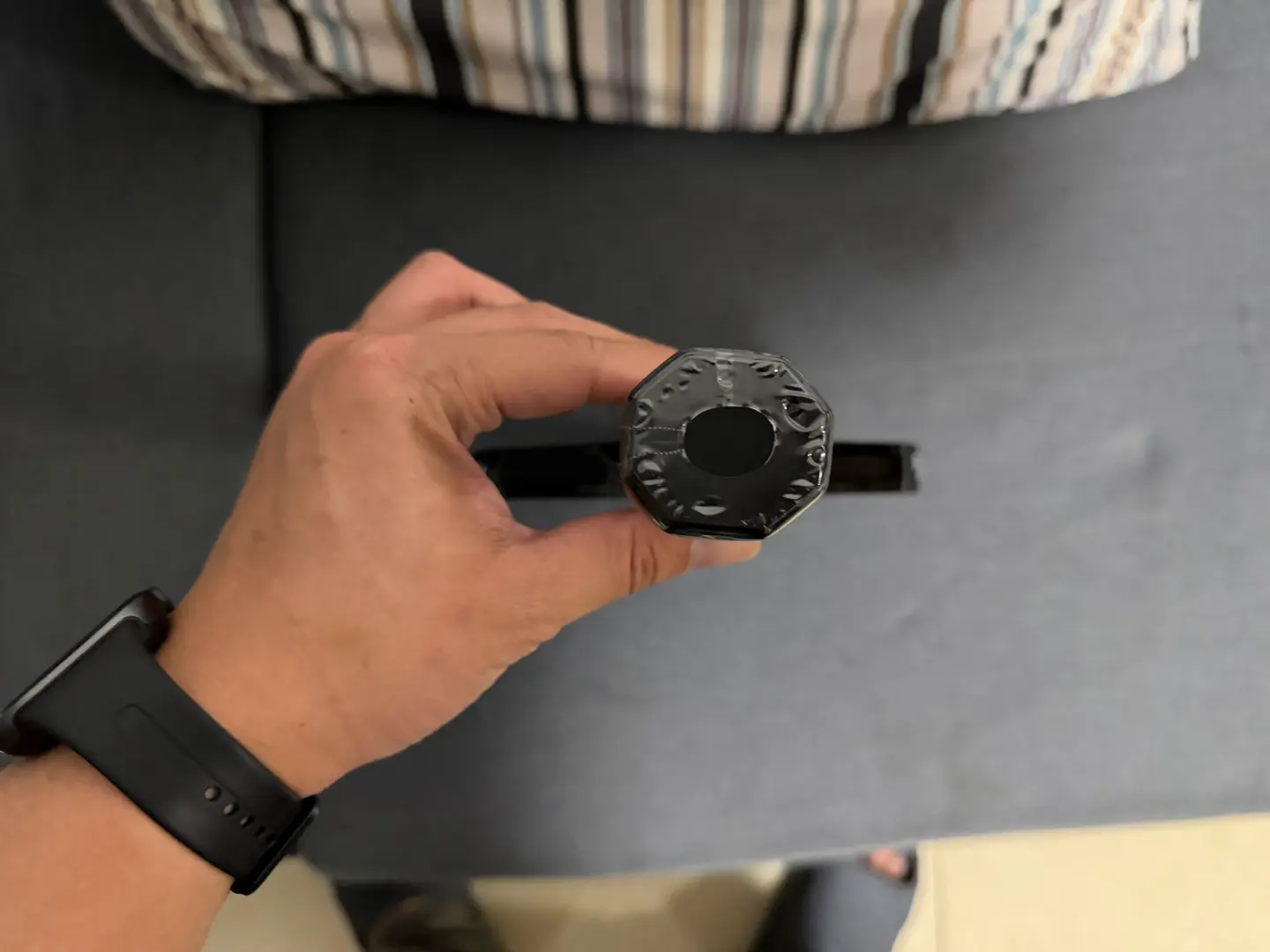 Project photograph of a dark paddle handle end cap held toward the camera